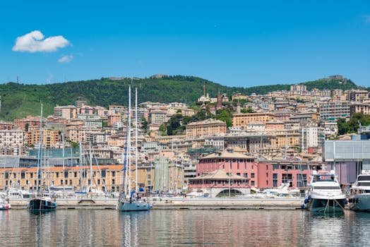 About Picturesque view of Genoa's marina with sailboats and a hillside townscape.